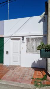 un garage blanc avec une porte et une fenêtre dans l'établissement El Refugio departamento 2, à Luján