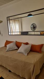 - une chambre avec un lit et un miroir au-dessus dans l'établissement El Refugio departamento 2, à Luján