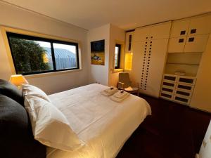Un dormitorio con una gran cama blanca y una ventana en Foz Velha House, en Oporto