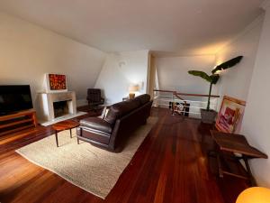 a living room with a leather couch and a fireplace at Foz Velha House in Porto