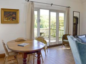a living room with a table and chairs and a balcony at Malthouse Barn in Hastingleigh