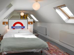 a bedroom with a large bed in a attic at Malthouse Barn in Hastingleigh