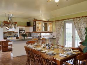 a kitchen and dining room with a wooden table with chairs at Gordons Hall Cottage in Carnbee