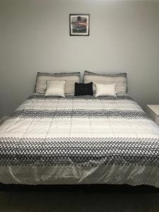 a bedroom with a large bed with a black and white comforter at Sweet Dreams in South Jordan