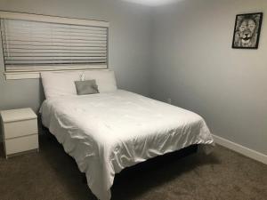 a bedroom with a white bed with a window at Sweet Dreams in South Jordan