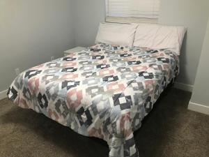 a bed with a comforter in a bedroom at Sweet Dreams in South Jordan