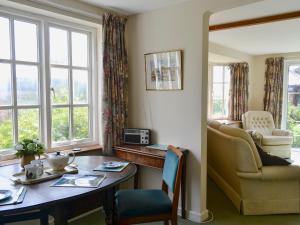 a living room with a table and a chair and windows at Valley View in Hawley Bottom