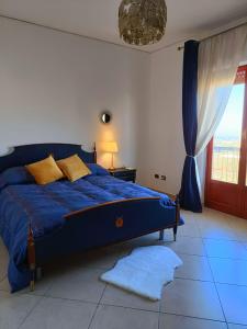 uma cama azul num quarto branco com uma janela em B&B Margherita em Bagheria