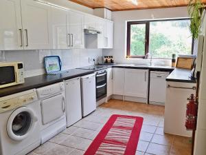 uma cozinha branca com um lavatório e uma máquina de lavar louça em Suncroft em Praa Sands