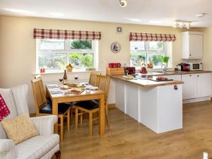 a kitchen and living room with a table and a kitchen and a dining room at Blackberry Cottage in North Hill