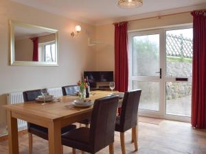 a dining room with a wooden table and chairs at Brynymor Cottage in Llangennith