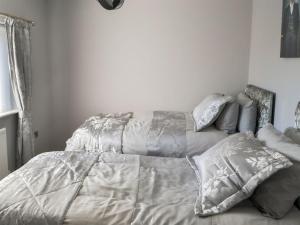 a bedroom with a bed with a comforter and pillows at Seashells By The Sea in Newbiggin-by-the-Sea