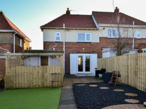 a backyard with a fence and a house at Seashells By The Sea in Newbiggin-by-the-Sea