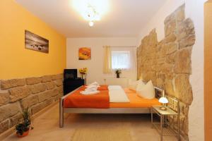 a bedroom with a king sized bed in a stone wall at Pension Stettin in Stadt Wehlen