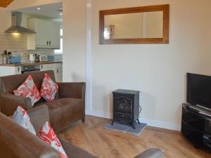 a living room with a couch and a stove at Y Gorlan in Llanllechid