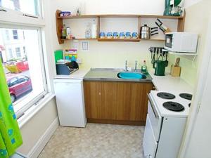 a small kitchen with a stove and a sink at Mayflower in Cromer