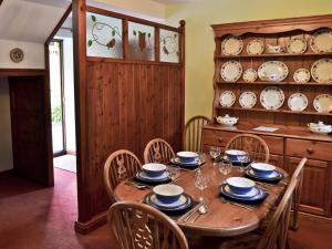 een eetkamer met een tafel met stoelen en borden bij The Coach House in Swanwick