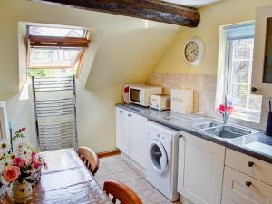 a kitchen with a sink and a washing machine at East Granary - 28956 in Eye