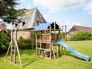 a tree house with a slide and a playground at East Granary - 28956 in Eye