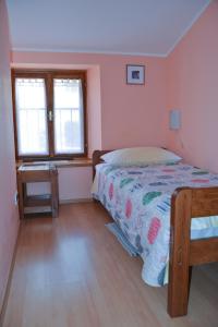 a bedroom with a bed and a desk and two windows at Sobe Pintur in Grožnjan