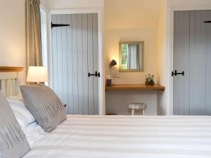 a bedroom with a large white bed and a mirror at One Parkhayes in Woodbury