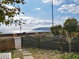 a wooden fence with a view of the ocean at Little Lismoy in Sandown