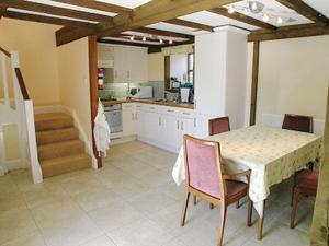 uma cozinha com mesa e cadeiras num quarto em Buzzard Barn em Saint Martins Green