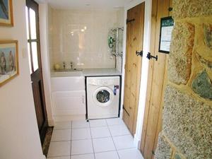 a bathroom with a washing machine and a sink at Buzzard Barn in Saint Martins Green