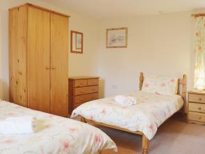 um quarto com 2 camas e um armário de madeira em Ger Yllan em Cross Inn