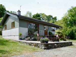 a small house with a porch and a patio at Tigh A Vullin - S4628 in Ardfern