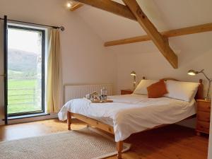 a bedroom with a bed and a large window at Y Stabl in Llanwrda