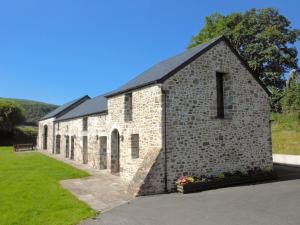 Llanwrda的住宿－亞斯塔貝爾鄉村別墅，黑色屋顶的旧砖砌建筑
