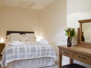 a bedroom with a bed with a mirror and a dresser at Nether Cottage in Saline