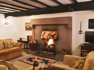 a living room with a fireplace and a couch at The Griffin in Broughton in Furness