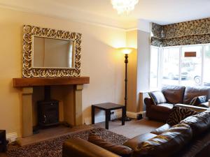 a living room with a couch and a fireplace at Craven House in West Burton