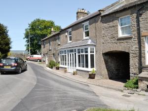 a car parked in front of a stone house at Craven House in West Burton