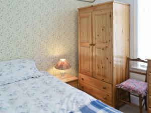 ファイリーにあるMalroseのベッドルーム1室(ベッド1台付)、木製キャビネットが備わります。