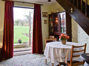 a dining room with a table and a large window at Sparrows Nest in Sampford Arundel