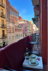 een tafel met borden en wijnglazen op een balkon bij Bonito apartamento muy céntrico in Bilbao