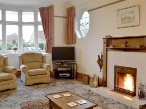 a living room with a fireplace and a tv at Colville House in Helmsley