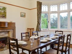 een eetkamer met een tafel en een open haard bij Colville House in Helmsley