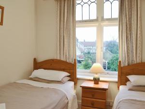 een slaapkamer met 2 bedden en een raam bij Colville House in Helmsley