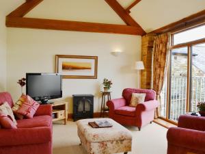 a living room with two chairs and a tv at Ash Tree Cottage in Bassenthwaite