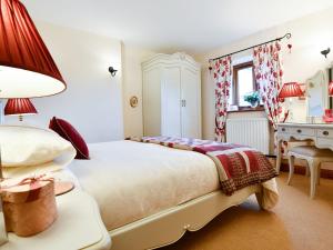 a bedroom with a large bed and a desk at Ash Tree Cottage in Bassenthwaite
