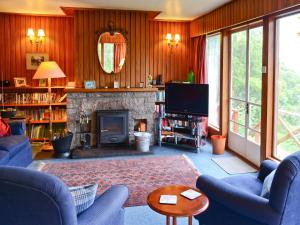 a living room with blue chairs and a fireplace at Camus Na Harry in Shieldaig