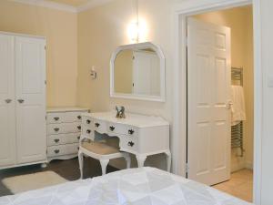a white bathroom with a sink and a mirror at The Cottage in Blackwood