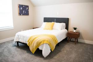 a bedroom with a large bed with a yellow blanket on it at The Nampa Family House in Nampa