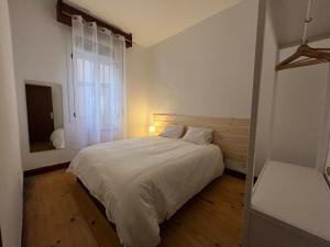 1 dormitorio con cama blanca y ventana en Bonito apartamento muy céntrico, en Bilbao