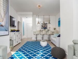 a living room with a blue and white rug at Marina Beach House, Torquay in Torquay