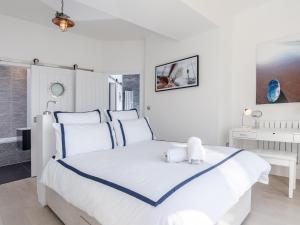 a white bedroom with a white bed and a sink at Marina Beach House, Torquay in Torquay